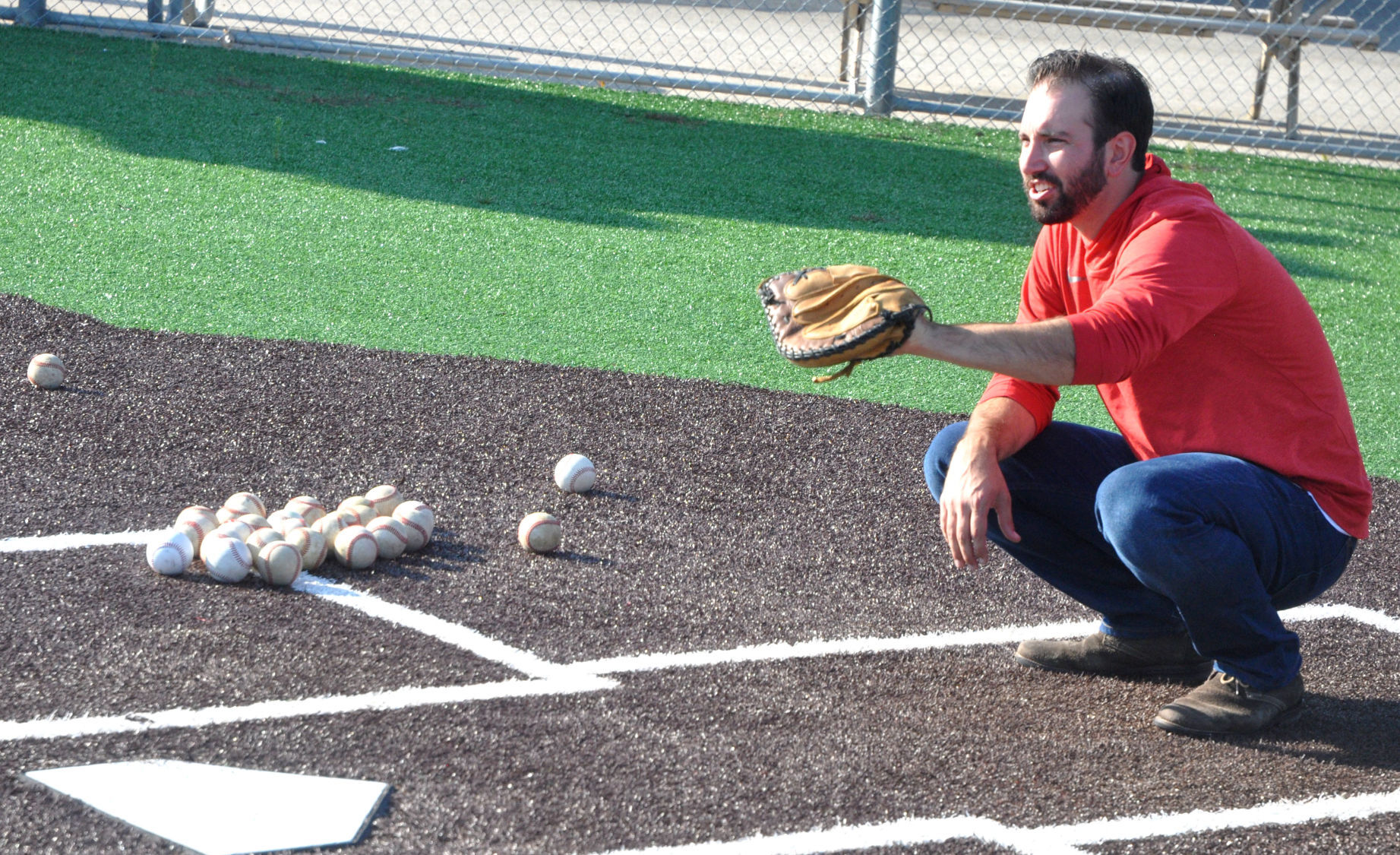 Badger High School baseball coach Michael Ploch prepares to catch some pitches thrown by Brooks Guif